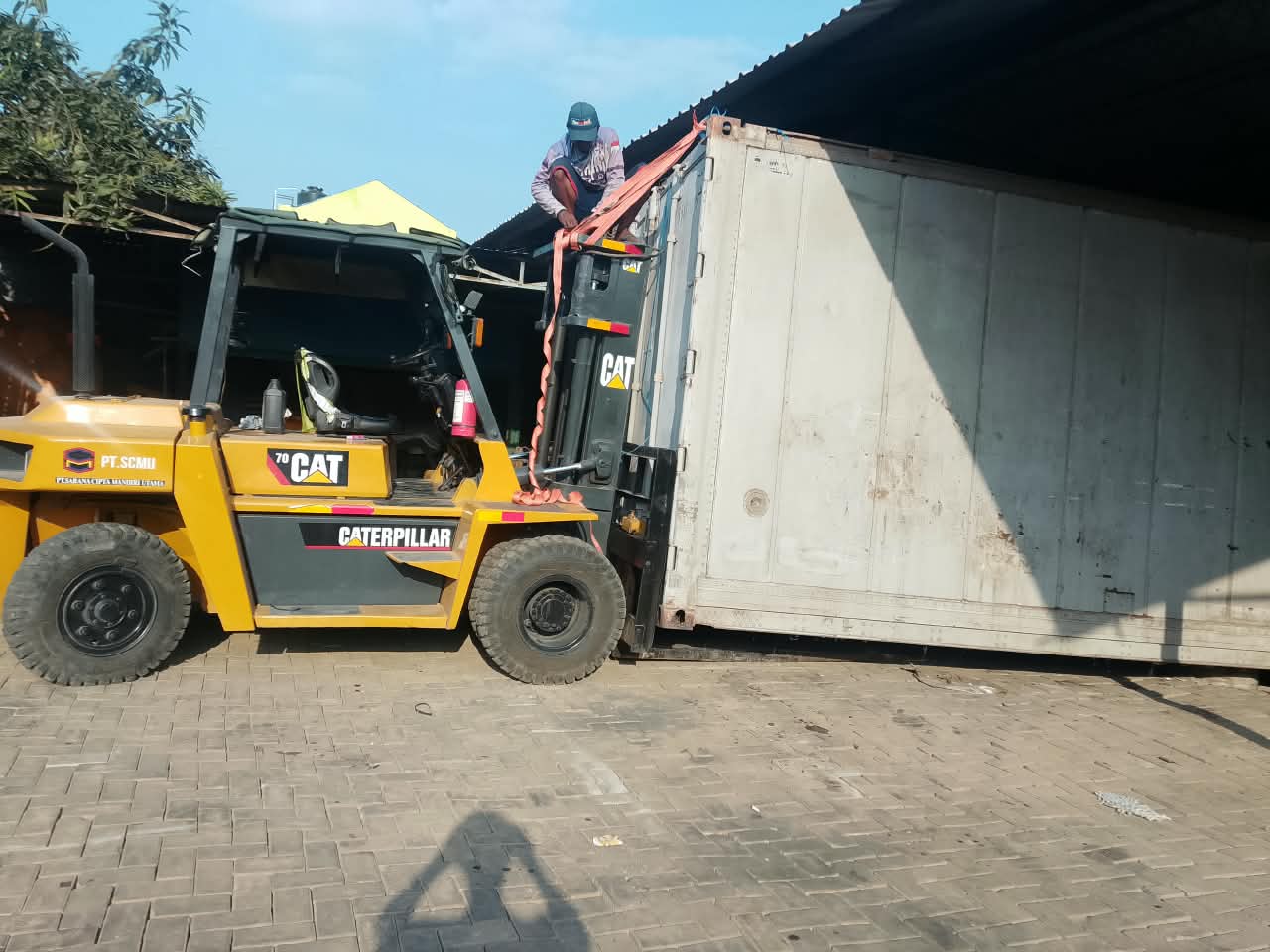 Forklift CAT SCMU memosisikan kontainer di area operasional