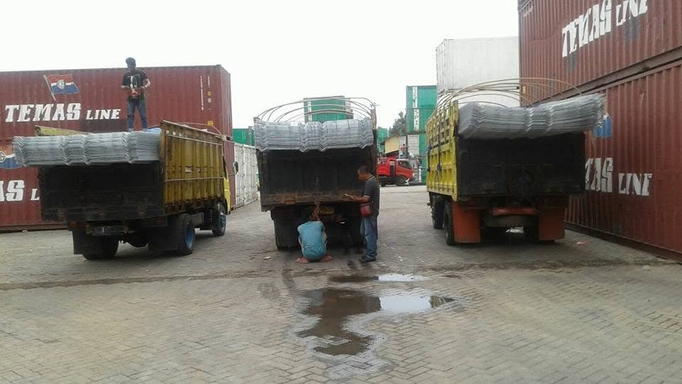 Tiga truk bermuatan material berada di area kontainer