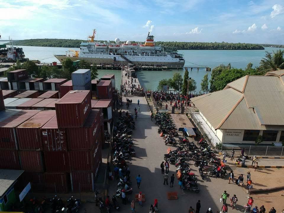 Kapal bersandar di pelabuhan dekat area kontainer