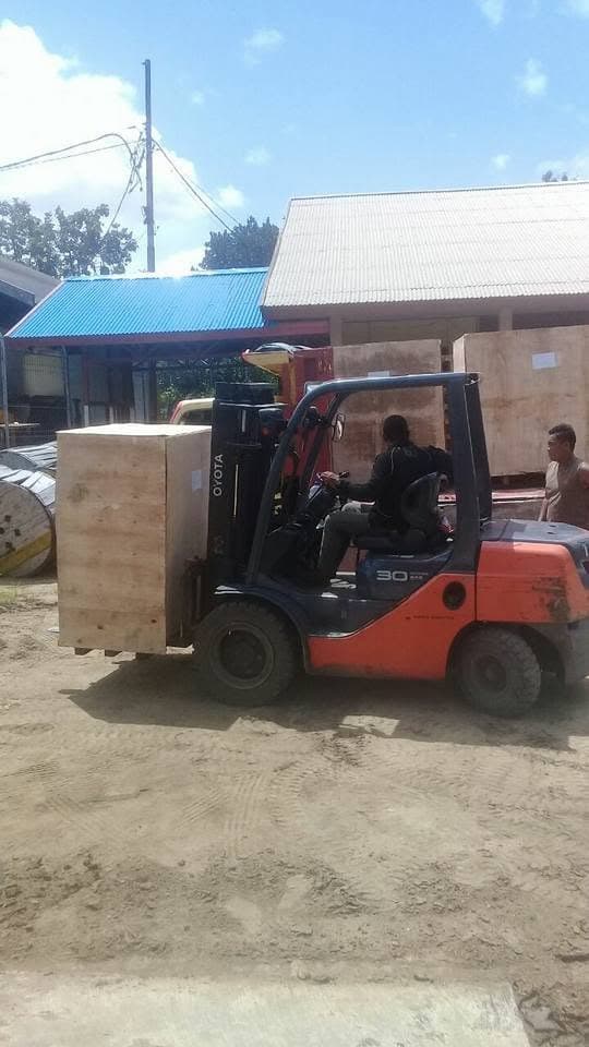 Forklift memindahkan peti kayu berukuran besar di area operasional