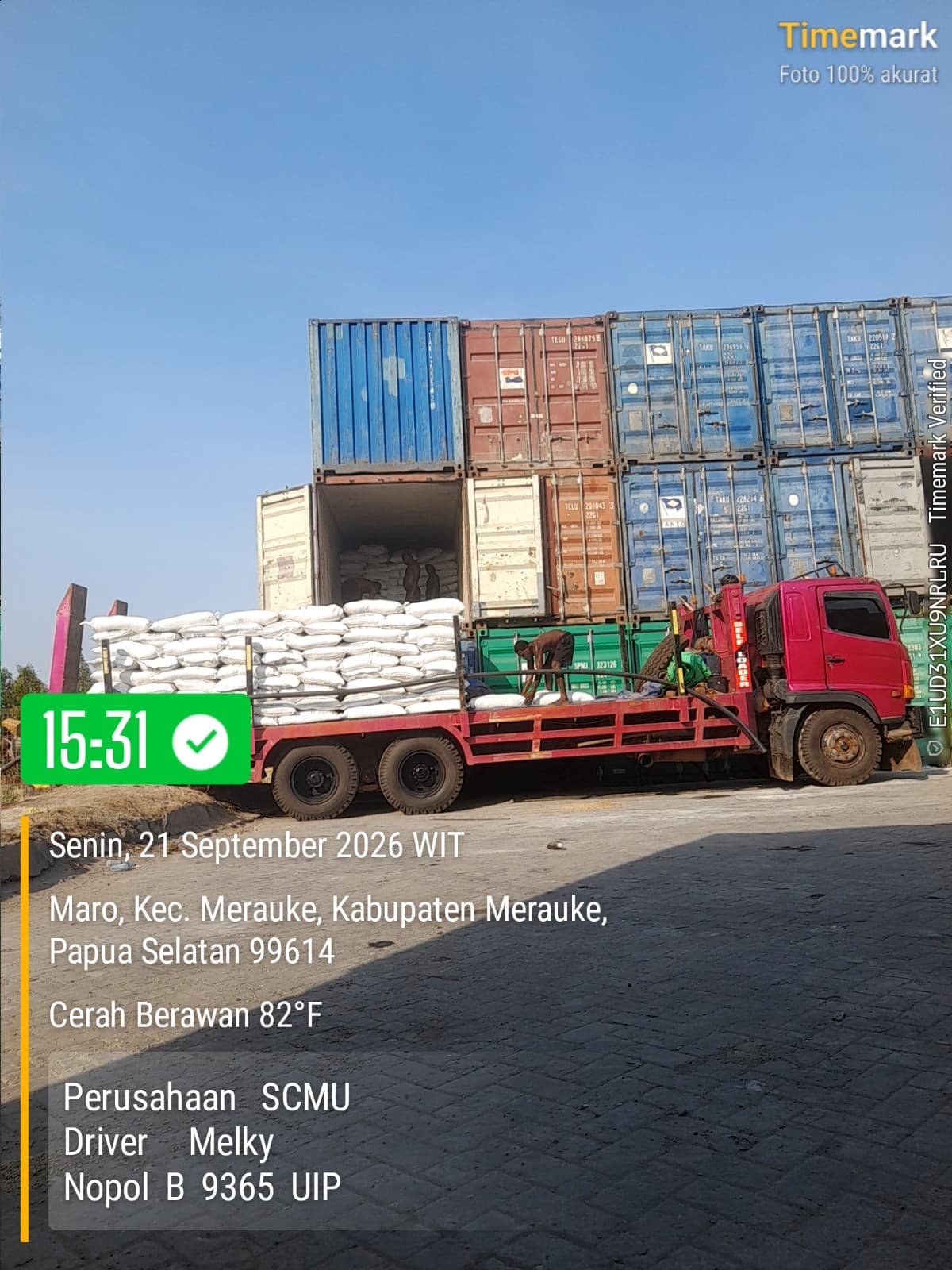 Pekerja memindahkan karung dari kontainer terbuka ke truk SCMU