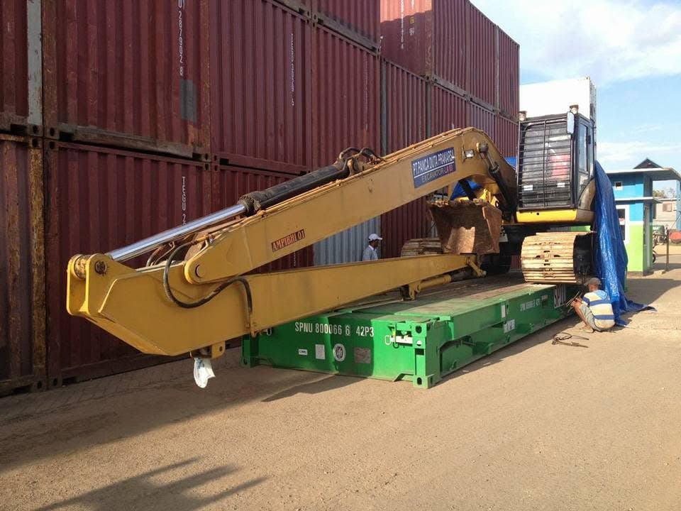 Ekskavator ditempatkan di atas flat rack di area kontainer